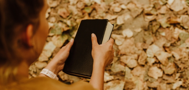 Kvinde med bibel. Foto: Unsplash.