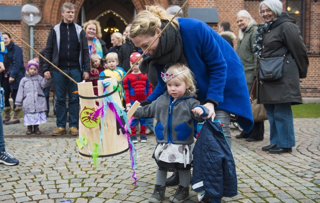 Uden for Sankt Jakobs kirke slår børnene katten af tønden. Her er det en lille prinsesse, der får hjælp til at give katten et dask. Foto: Søren Bidstrup/Scanpix.